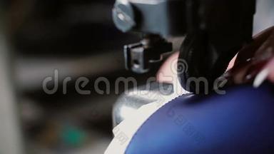 女人在缝纫机上做一个光滑的接缝。 工人为制鞋缝制皮革。 女士缝纫件在一起。 4K